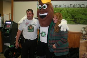 Spudly poses with store director Don Theisen, left and Carrie Theisen, right. The Theisens created many of the Wisconsin potato displays that were located throughout the store in October.