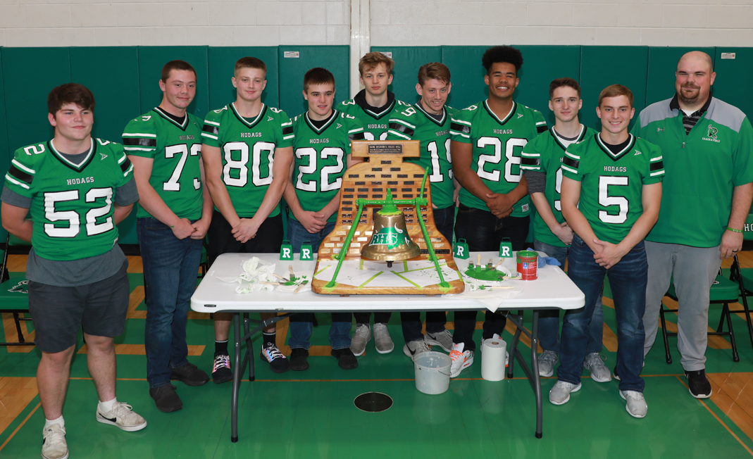 The nine senior players and coach Kraemer pose with the repainted bell.