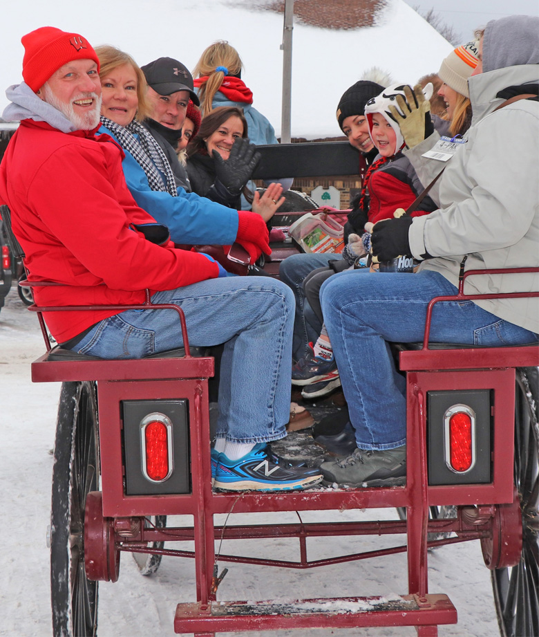 Friendly wave as they pass through Veterans Park on the horse-drawn wagon ride.