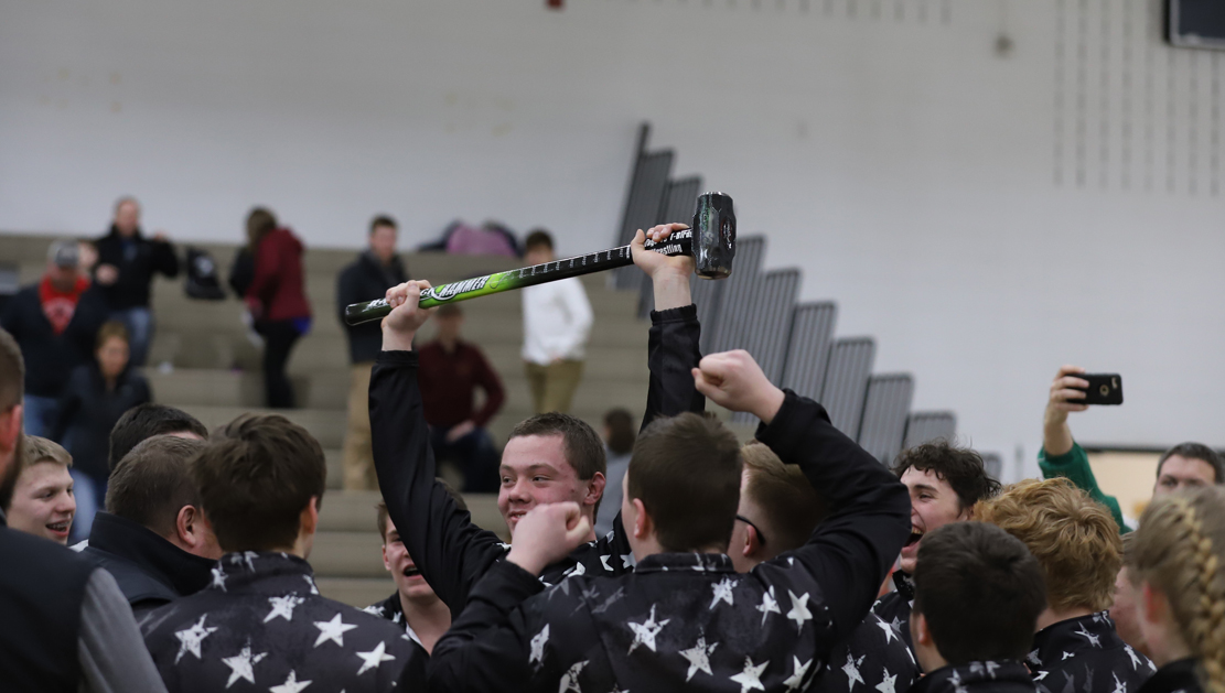 Trevor Knapp holds the hammer high in celebration with teammates and coaches.