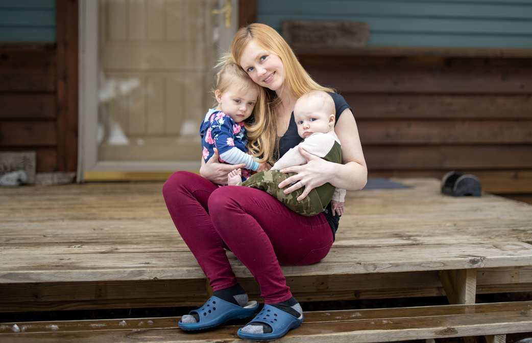 Britta Herrick is pictured on her front porch with her young children.