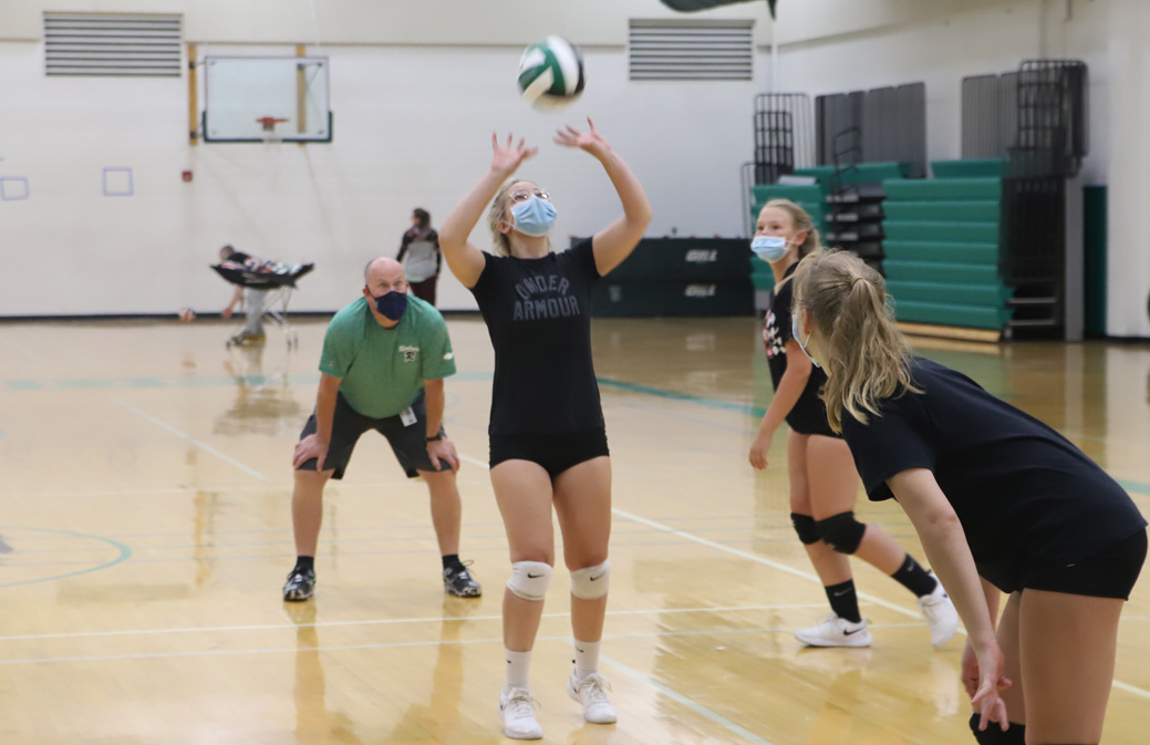 Under the watchful eye of coach Povolo, senior Olivia Verbeest sets the ball.