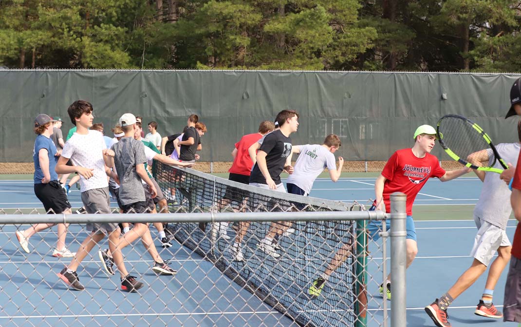 Tennis players began practice with some warm-up running and stretching.