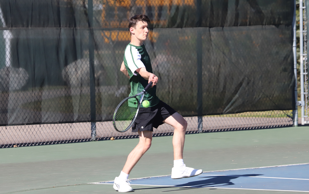 Junior Elijah Evers returns a forehand volley at No. 1 doubles.