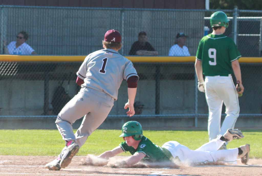 Isaac Bixby slides safely at home plate after a wild pitch.